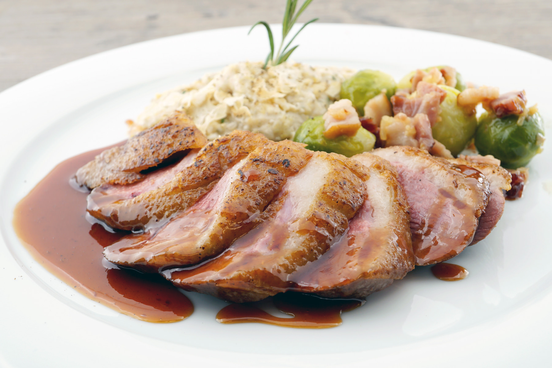 Gebratenes Appenzeller Ribelmais Entenbrüstchen Blutorangensauce mit Zimt Ästchen, Polenta vom Belpberg & Rosenkohl mit Speck